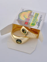 Load image into Gallery viewer, Gold rings with green gemstones on a Melon bubble gum pack.
